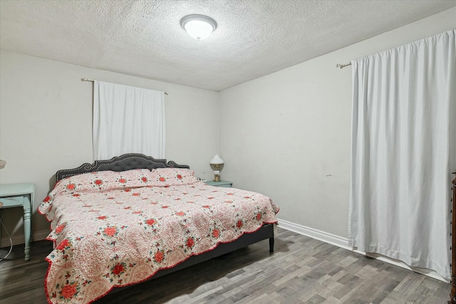 bedroom with wood-type flooring and a textured ceiling