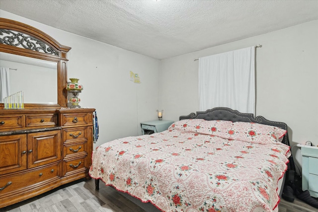 bedroom featuring light hardwood / wood-style flooring and a textured ceiling