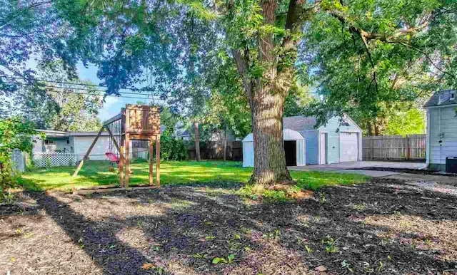 view of yard with a playground, a garage, and a storage unit