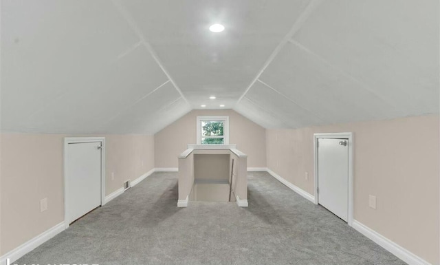 bonus room featuring lofted ceiling and light colored carpet