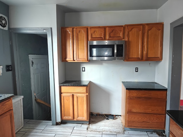 kitchen featuring light hardwood / wood-style floors and dark stone counters