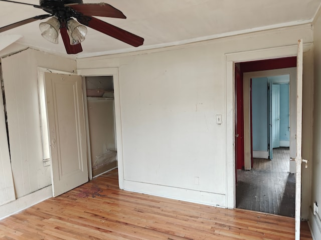 unfurnished bedroom with ceiling fan, a closet, and light wood-type flooring