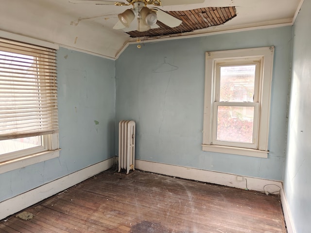 unfurnished room with ceiling fan, radiator heating unit, wood-type flooring, and vaulted ceiling