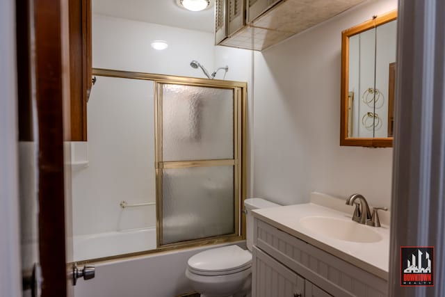 full bathroom featuring vanity, toilet, and shower / bath combination with glass door