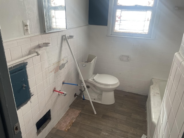 bathroom with toilet, tile walls, and hardwood / wood-style flooring