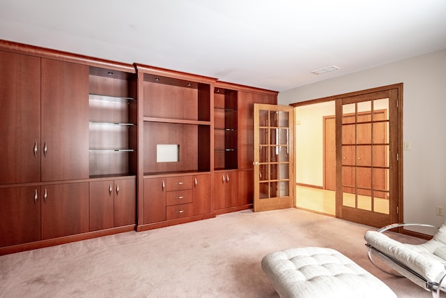unfurnished room with light colored carpet, visible vents, and french doors