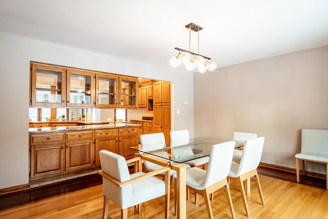 dining space featuring light wood-type flooring and a chandelier