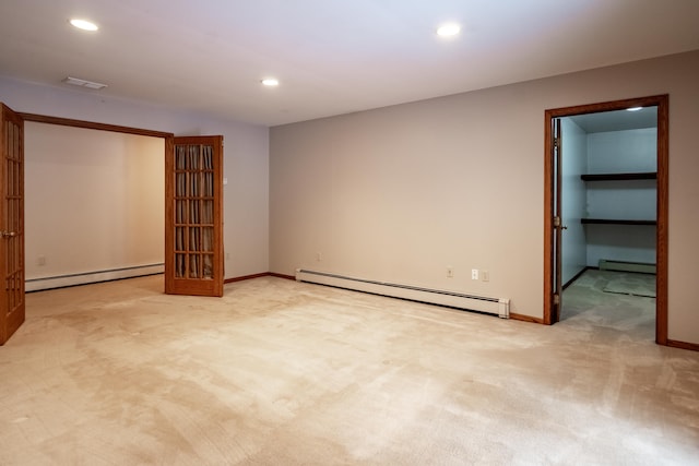 carpeted empty room featuring a baseboard heating unit, visible vents, and recessed lighting