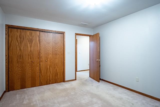 unfurnished bedroom with carpet, a closet, baseboards, and visible vents