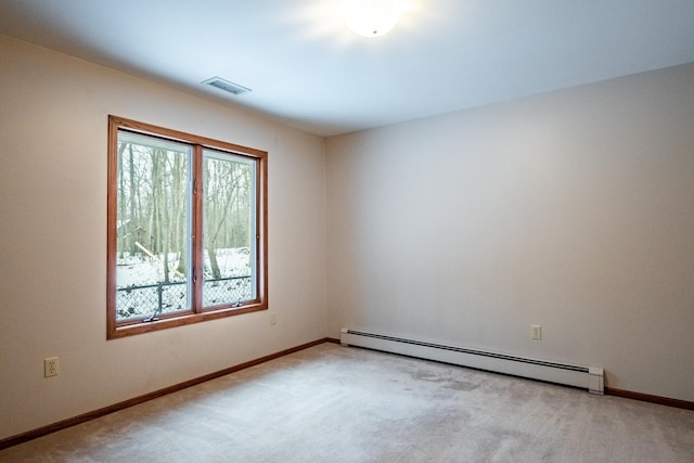 empty room with baseboards, baseboard heating, visible vents, and light colored carpet