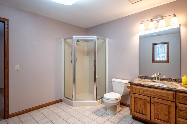 bathroom with a stall shower, vanity, toilet, and tile patterned floors