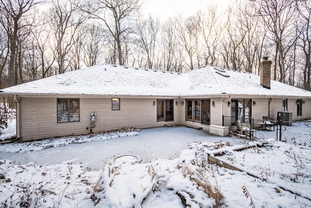 snow covered property with central AC unit