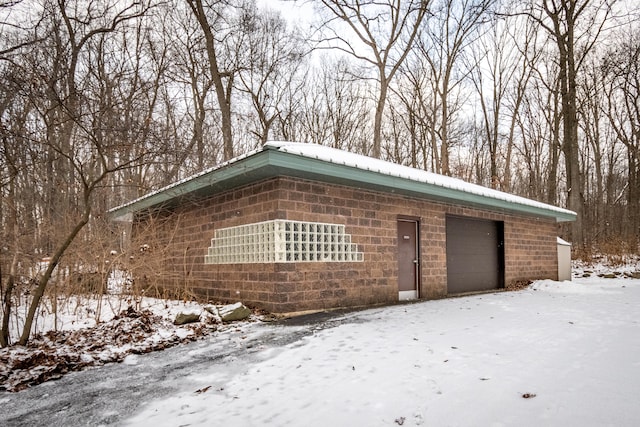 snow covered garage featuring a garage