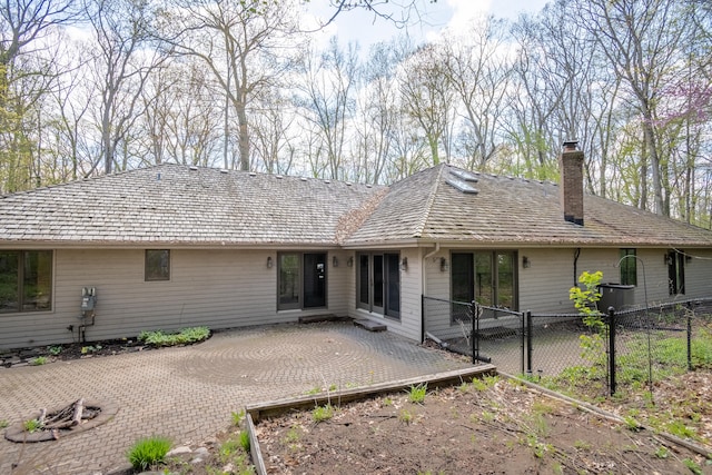 back of house featuring a chimney, a patio area, and fence