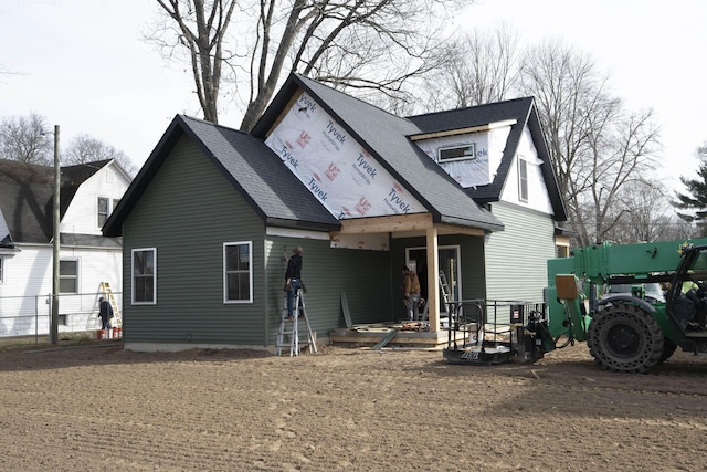 exterior space with fence and a shingled roof