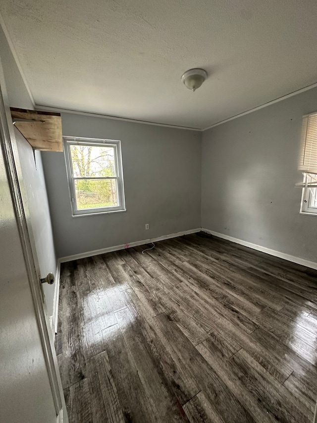 spare room with dark wood-type flooring and a textured ceiling