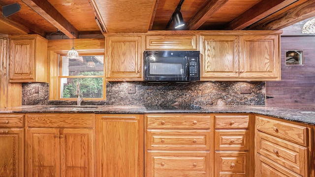 kitchen featuring dark stone countertops, sink, backsplash, and black appliances