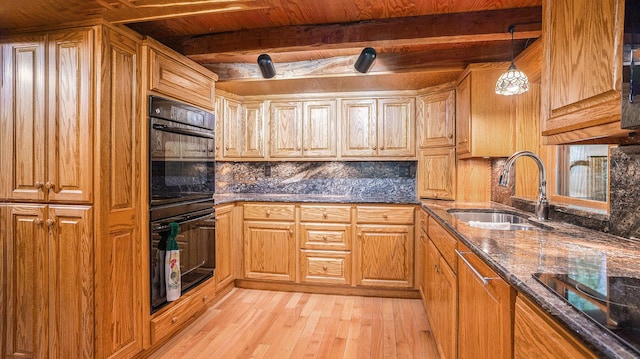 kitchen with pendant lighting, beamed ceiling, sink, light hardwood / wood-style floors, and black appliances