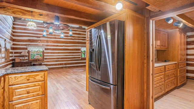 kitchen with pendant lighting, wooden walls, stainless steel refrigerator with ice dispenser, beamed ceiling, and light wood-type flooring