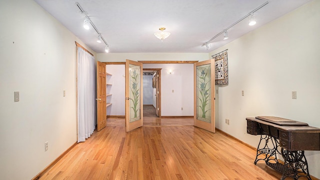 unfurnished room featuring rail lighting and light hardwood / wood-style floors