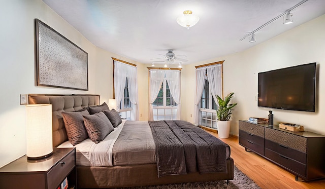 bedroom featuring rail lighting and light hardwood / wood-style floors