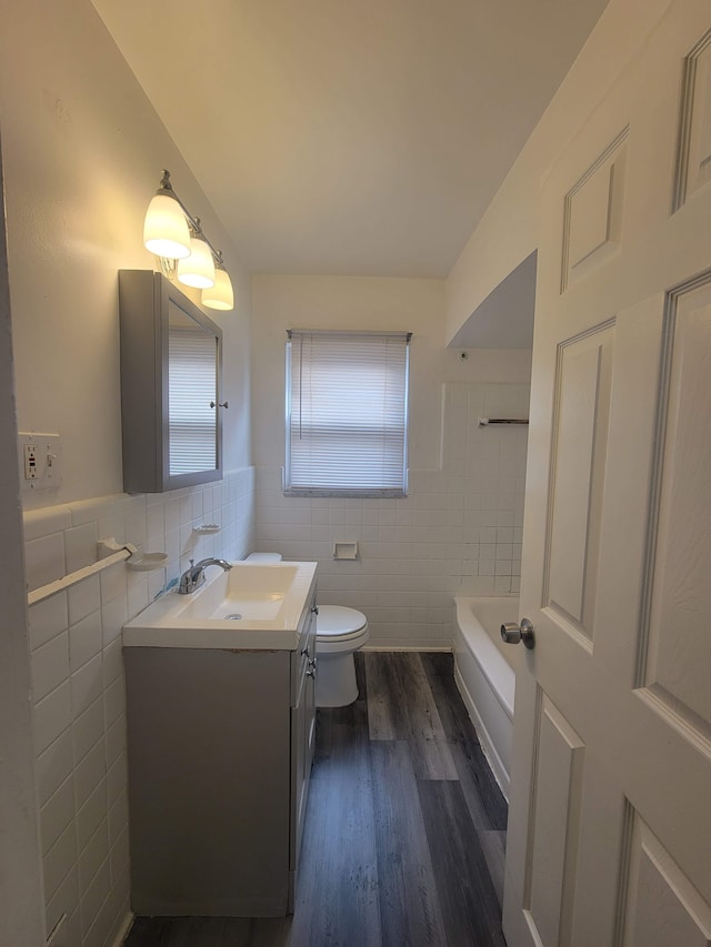 bathroom featuring hardwood / wood-style floors, vanity, toilet, and tile walls