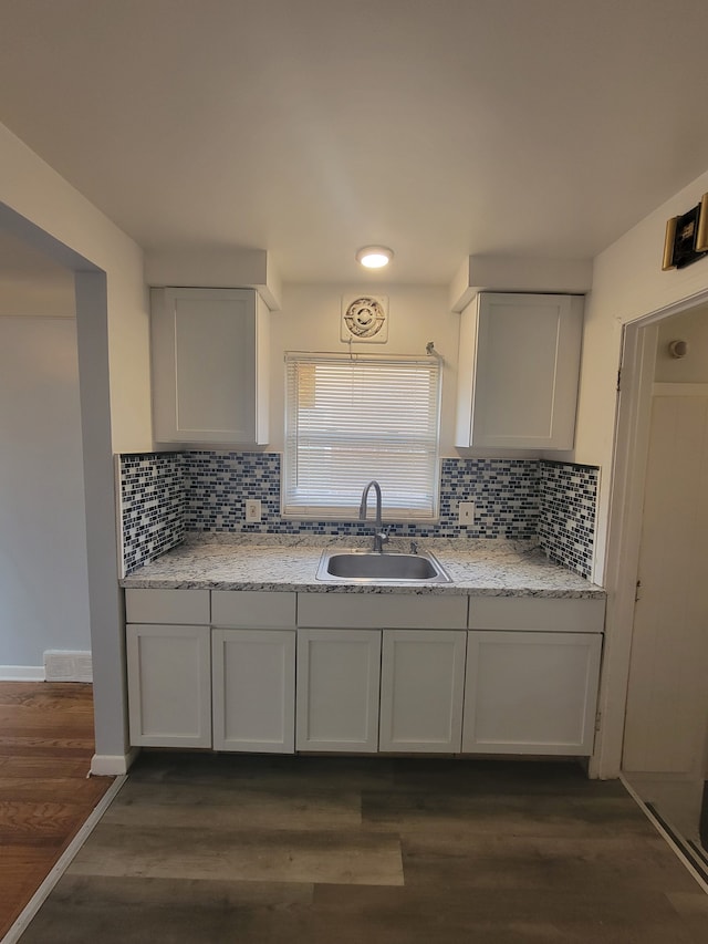 kitchen featuring backsplash, dark hardwood / wood-style flooring, white cabinetry, and sink