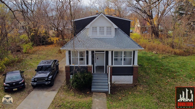 bungalow with a porch and a front lawn