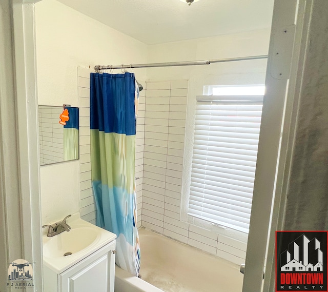 bathroom with shower / tub combo, vanity, and plenty of natural light