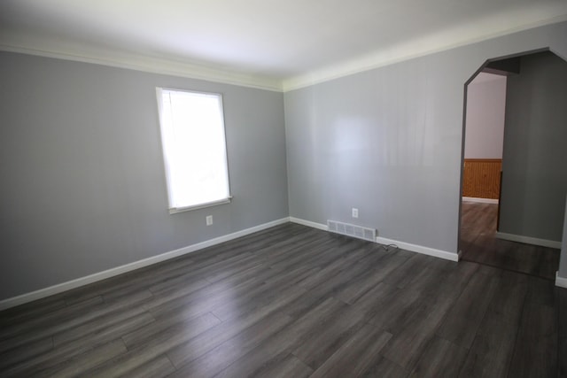 empty room with dark hardwood / wood-style floors and ornamental molding