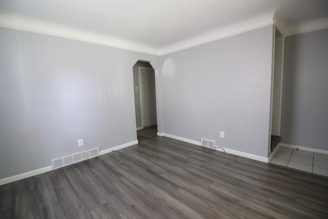 spare room featuring dark wood-type flooring and ornamental molding