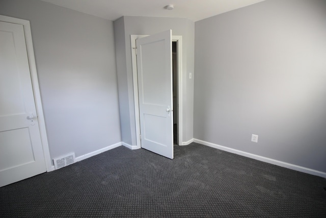 unfurnished bedroom with dark carpet