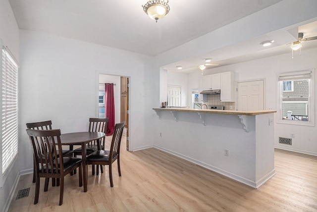 dining space featuring ceiling fan and light wood-type flooring