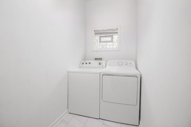 laundry area with light tile patterned floors and washer and clothes dryer