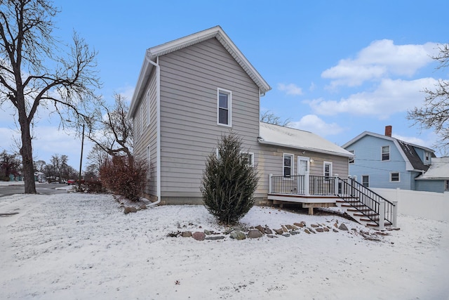 snow covered house with a deck