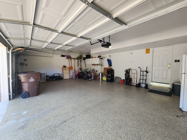 garage featuring white refrigerator and a garage door opener