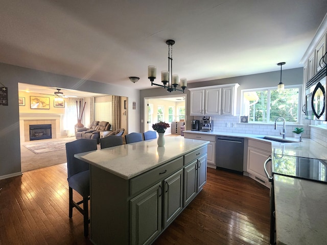 kitchen featuring appliances with stainless steel finishes, a kitchen breakfast bar, a healthy amount of sunlight, white cabinets, and a kitchen island