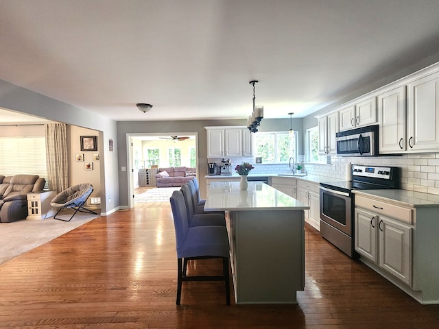 kitchen featuring white cabinets, stainless steel appliances, and a healthy amount of sunlight