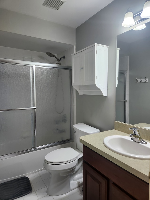 full bathroom featuring tile patterned floors, vanity, toilet, and combined bath / shower with glass door