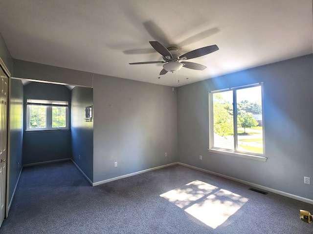 carpeted spare room featuring ceiling fan