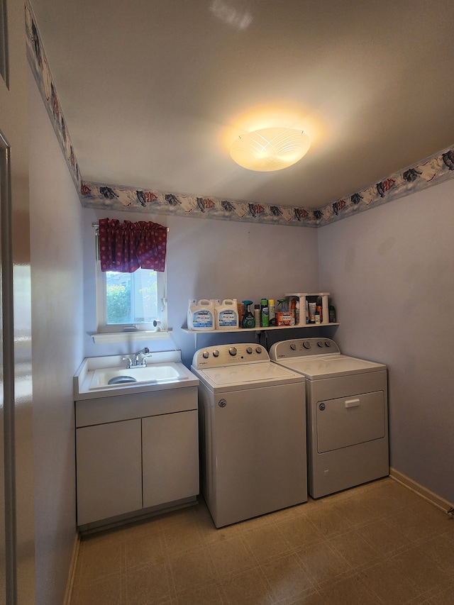 laundry area featuring cabinets, washing machine and dryer, and sink