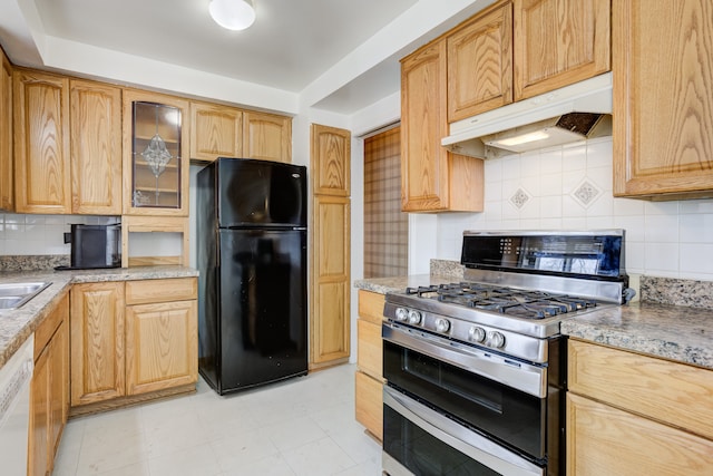 kitchen featuring dishwasher, stainless steel gas stove, black fridge, and backsplash