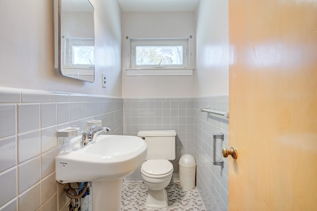 bathroom with tile patterned flooring, tile walls, and toilet