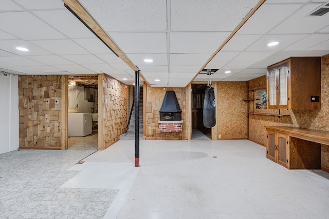 basement with a drop ceiling and washer / clothes dryer