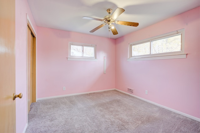 spare room with ceiling fan and light colored carpet