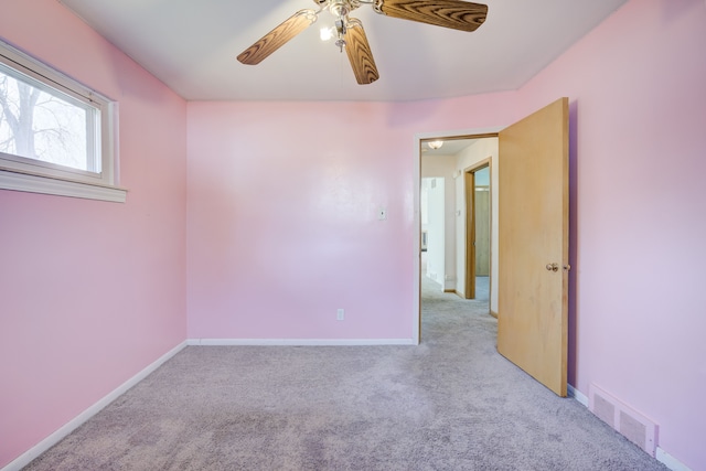 carpeted spare room with ceiling fan