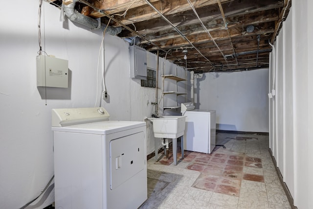 laundry area featuring electric panel, separate washer and dryer, and sink