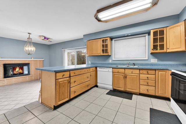 kitchen with light tile patterned flooring, hanging light fixtures, white appliances, and a brick fireplace