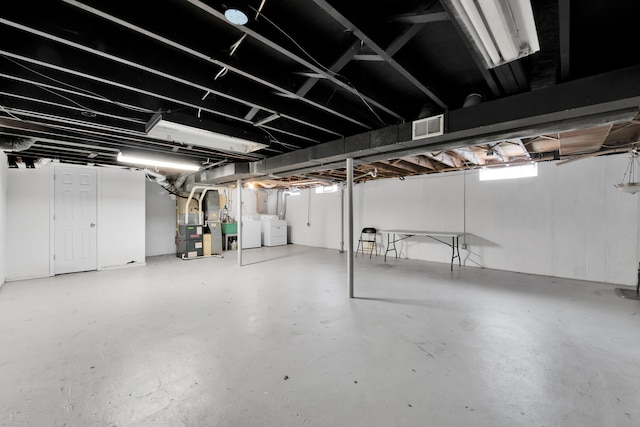 basement with washing machine and dryer and heating unit