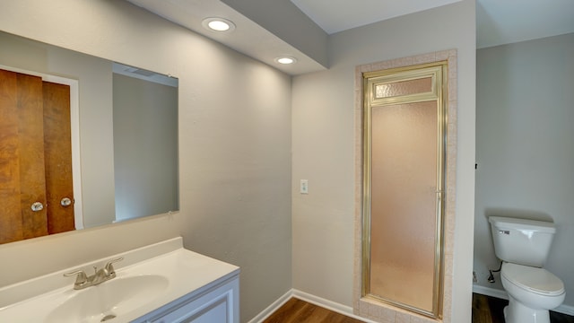 bathroom with toilet, vanity, an enclosed shower, and hardwood / wood-style flooring